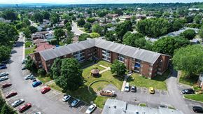 Gatineau apartment for rent - A parking lot with cars and a building in the background.