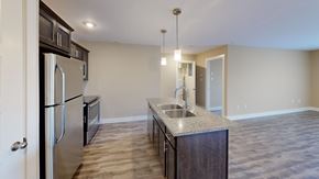 Saint John townhouse for rent - A kitchen with a refrigerator, sink, and cabinets.