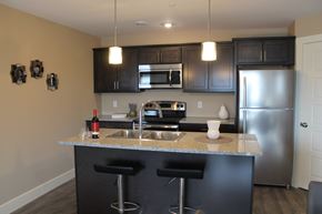 Saint John townhouse for rent - A kitchen with a black counter top and stools.