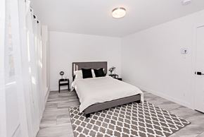 Val D'or apartment for rent - A bedroom with a large bed and a patterned rug.