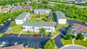Gatineau apartment for rent - A parking lot with cars and a building in the background.