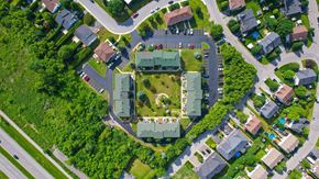 Gatineau apartment for rent - A bird's eye view of a residential area with houses and a large green building in the center.