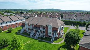 Gatineau apartment for rent - A large red brick house with a white staircase in front.