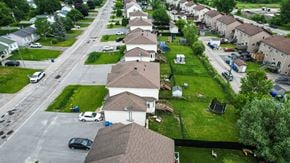 Gatineau townhouse for rent - A residential street with houses on both sides and cars parked on the street.