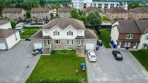Gatineau townhouse for rent - A large house with a driveway and a car parked in front.