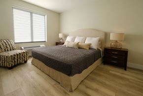 Saint John townhouse for rent - A bedroom with a large bed and a chair.