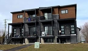 Embrun apartment for rent - A large multi-story building with balconies and stairs.