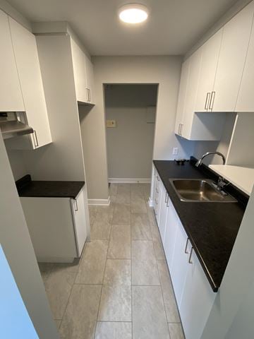 Gatineau townhouse for rent - A kitchen with white cabinets and a black countertop.