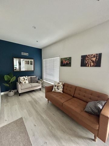 Gatineau townhouse for rent - A living room with a brown couch and a mirror on the wall.
