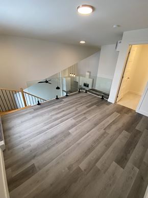 Gatineau townhouse for rent - A spacious room with a staircase and a glass railing.
