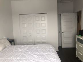 Embrun apartment for rent - A white bed with a white comforter and pillow in a white room.