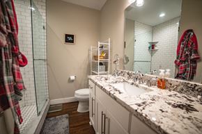 Kansa City apartment for rent - A bathroom with a white toilet, a sink, and a mirror.