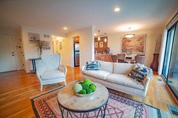 Kansas City apartment for rent - A living room with a white couch, a chair, and a table with fruit on it.