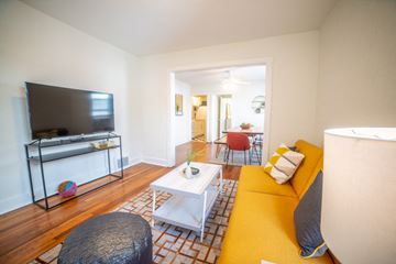 Kansas City apartment for rent - a living room with a yellow couch and a television