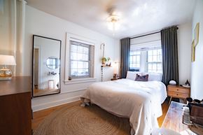 Kansas City apartment for rent - A bedroom with a large bed and a mirror on the wall.