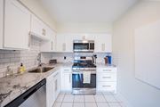 Kansas City apartment for rent - A kitchen with white cabinets and a black dishwasher.