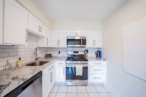 Kansas City apartment for rent - A kitchen with white cabinets and a black dishwasher.