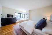 Kansas City apartment for rent - A bedroom with a large bed and a dresser with a flat screen TV on top.