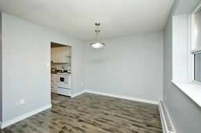 Oshawa apartment for rent - A room with a wooden floor and a window on the right side.