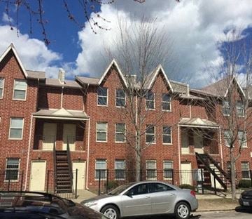 Chicago apartment for rent - a car parked in front of a brick apartment building