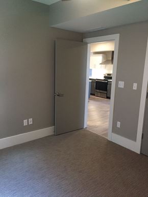 St. Louis apartment for rent - a bedroom with a door open to a hallway and a kitchen
