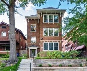 St. Louis apartment for rent - A red brick house with a black metal railing.