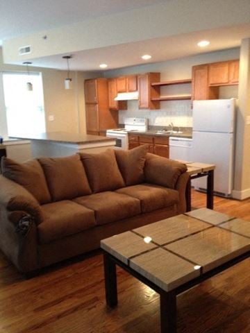 St. Louis apartment for rent - A brown couch sits in a kitchen with a white refrigerator.