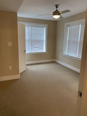 Saint Louis apartment for rent - A room with a ceiling fan and two windows.