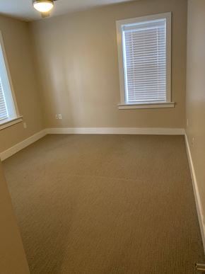 Saint Louis apartment for rent - A room with a carpeted floor and a window with blinds.