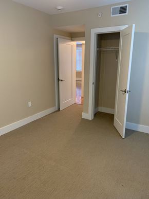 Saint Louis apartment for rent - a bedroom with a closet and a hallway with an open door