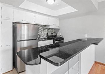 Minneapolis apartment for rent - a kitchen with a black counter top and a stainless steel refrigerator