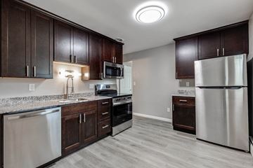 N. St. Paul apartment for rent - A kitchen with dark wood cabinets and stainless steel appliances.