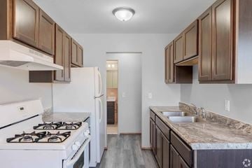 Richfield apartment for rent - A kitchen with a white stove and a sink with a marble countertop.