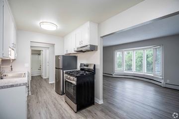 Richfield apartment for rent - A kitchen with a black stove top oven and a white fridge.