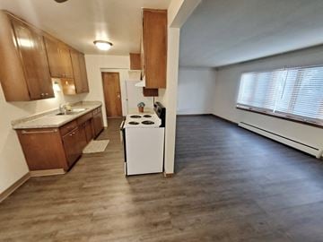 St. Paul apartment for rent - A kitchen with a white stove top oven and wooden cabinets.