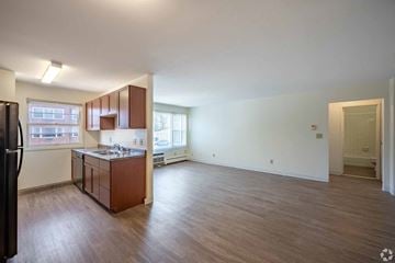 Maplewood apartment for rent - A kitchen with brown cabinets and a black refrigerator.