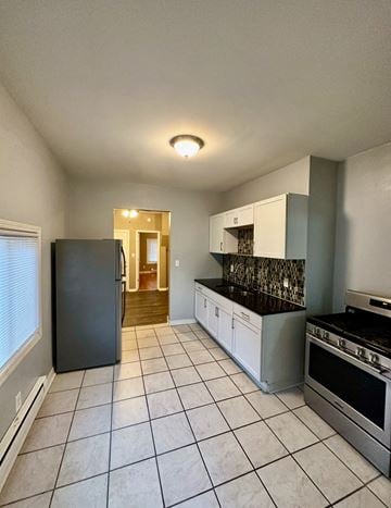 St. Paul apartment for rent - A kitchen with a black fridge, white cabinets, and a black stove top oven.