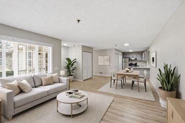 Vadnais Heights apartment for rent - A modern living room with a grey sofa, a coffee table, and a dining table set up.