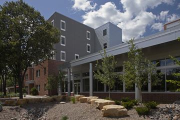 Minneapolis apartment for rent - A modern building with a grey facade and a landscaped area in front.