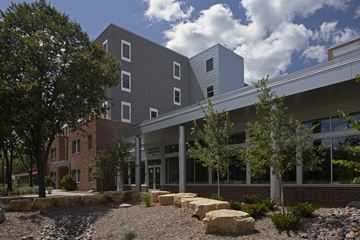 Minneapolis apartment for rent - a large building with trees and rocks in front of it