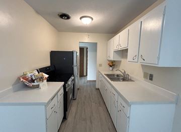 St. Paul apartment for rent - a kitchen with white cabinets and a black stove and a sink