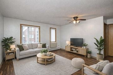 St. Paul apartment for rent - A living room with a grey couch, a wooden coffee table, and a television on a wooden stand.