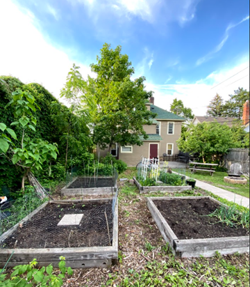 Minneapolis apartment for rent - a community garden with several plots and a house in the background
