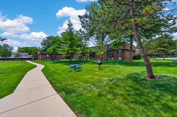 Expansive green space with picnic area at drawbridge apartments in harrison township, mi.