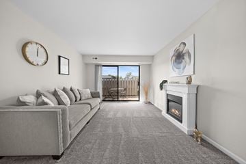 Troy apartment for rent - A living room with a grey couch and a fireplace.