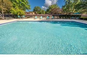 Westland apartment for rent - Heated pool equipped with comfy lounge chairs at Westwood Village Apartments in Westland, MI