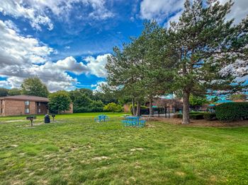 Spacious outdoor picnic and grilling area at westwood village apartments in westland, mi.