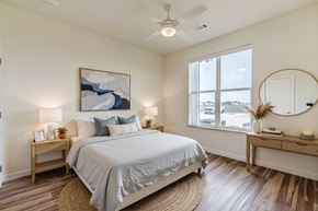 Maxwell apartment for rent - A bedroom with a large bed, a painting on the wall, and a round mirror on the dresser.