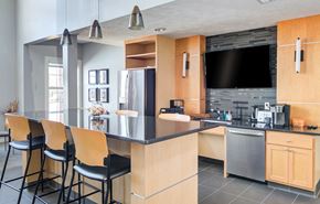 Omaha townhouse for rent - a kitchen with a large island with bar stools and a tv in a house at The Bluffs at Cherry Hills, Omaha