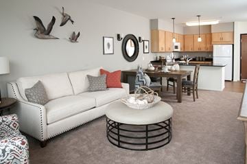 Prior Lake apartment for rent - a living room with a couch and a table in front of a kitchen